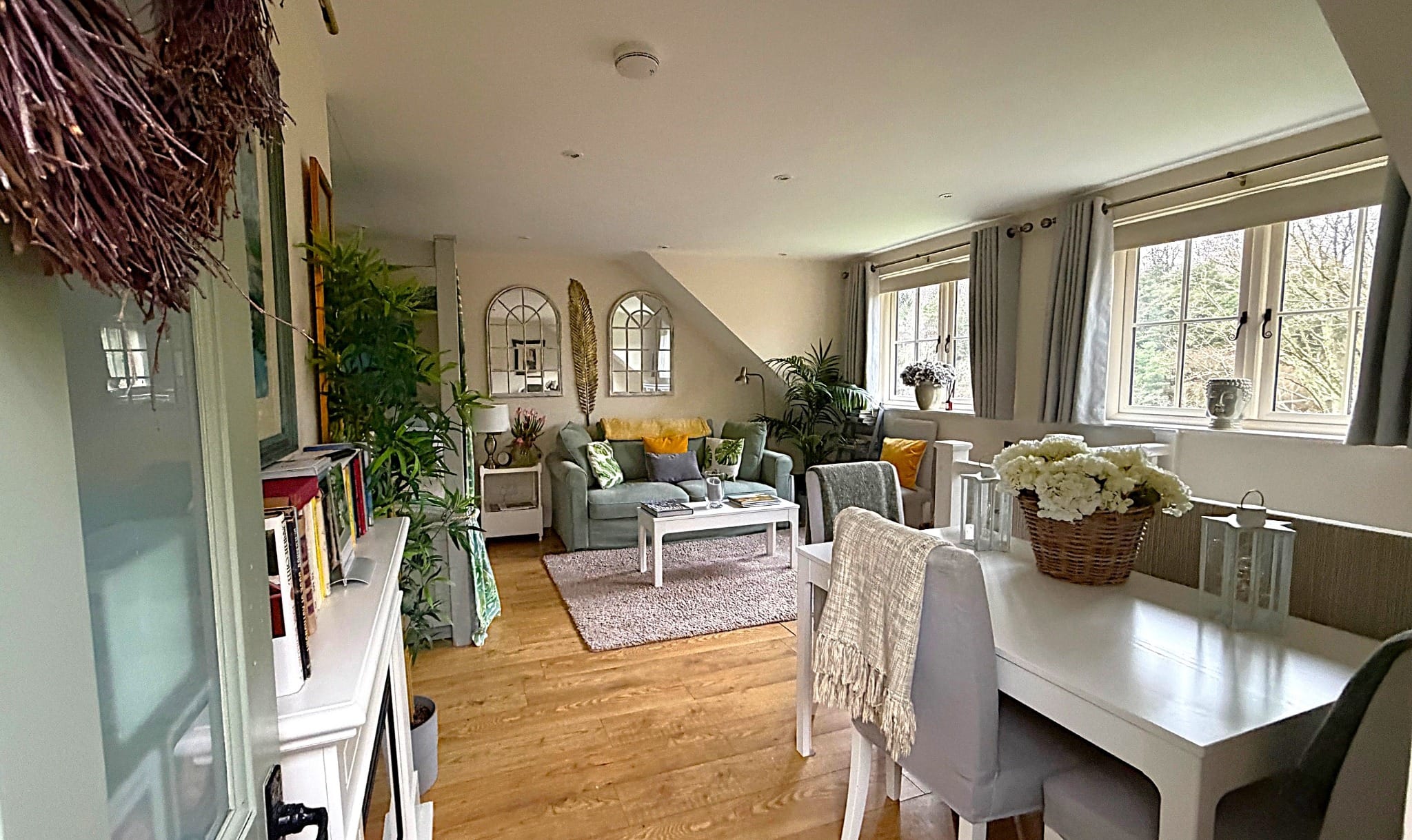 Bright open-plan living and dining room with neutral decor, wooden flooring and natural light