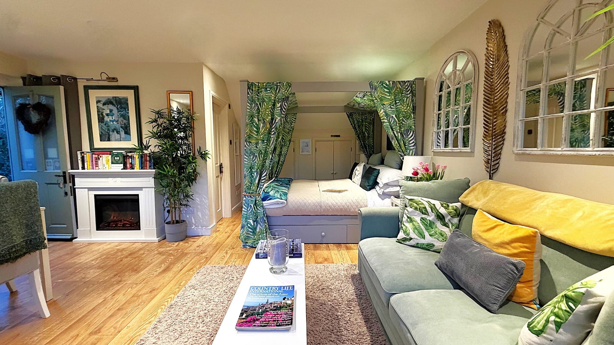 Cosy open-plan studio apartment with canopy bed, sofa and modern decor