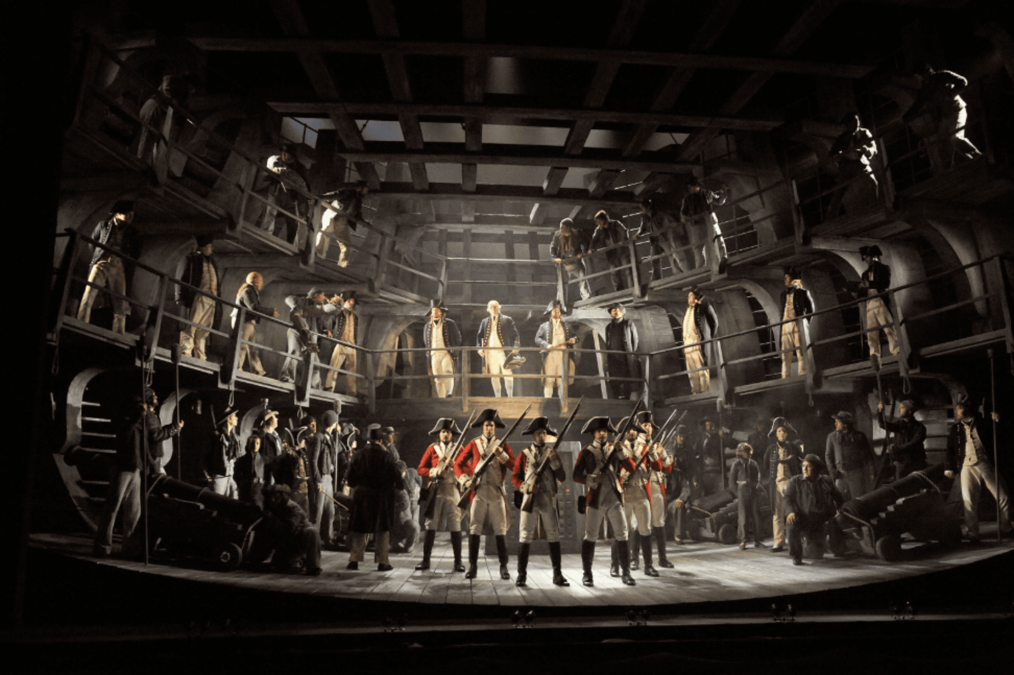 Large ensemble opera scene on stage with performers in historical military costumes