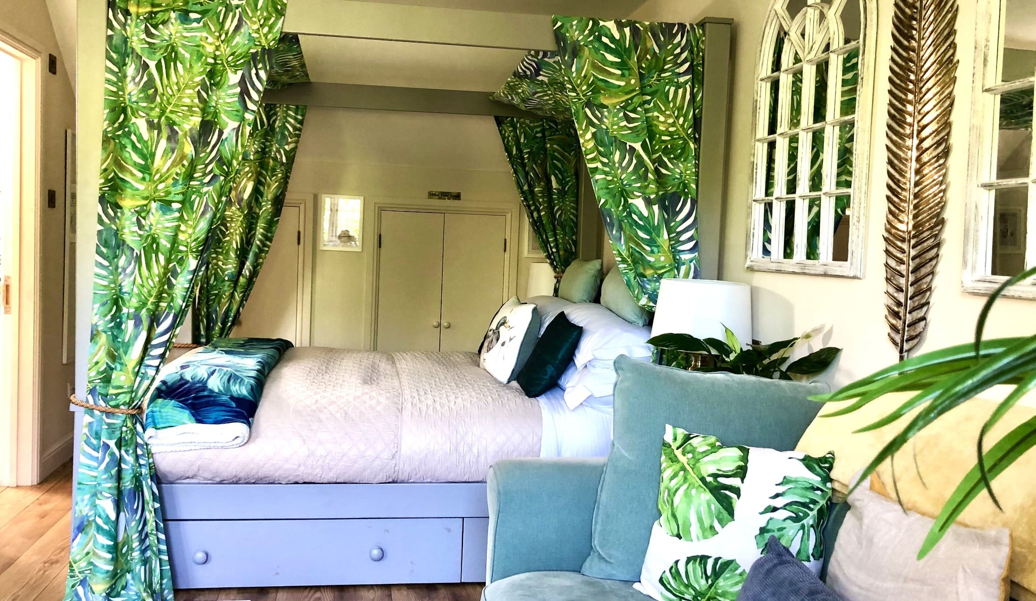 Self-Contained Holiday Cottage Accommodation In Sussex tropical themed bedroom with leaf canopy bed and green decor