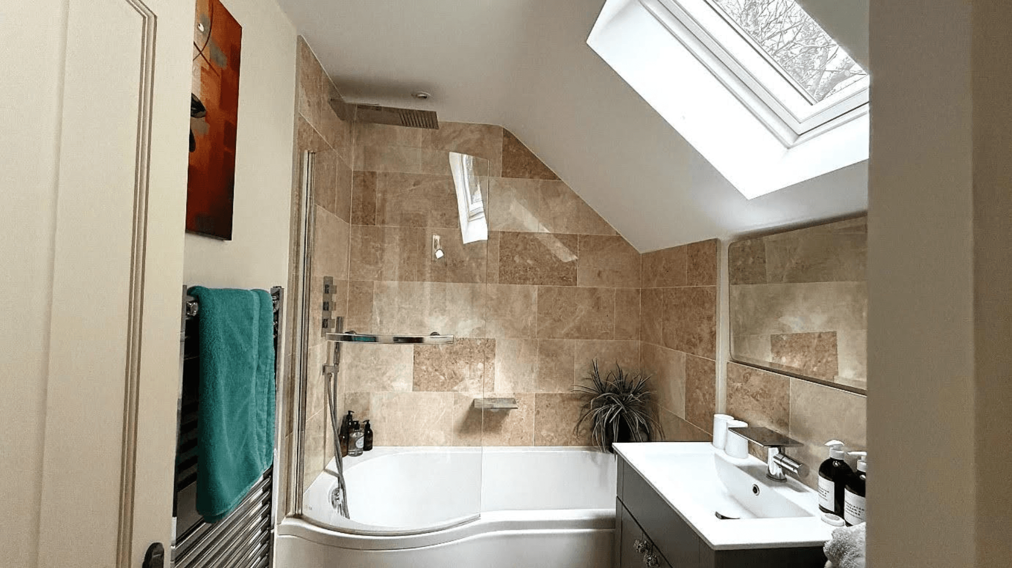 Modern bathroom with bath shower, skylight and tiled walls