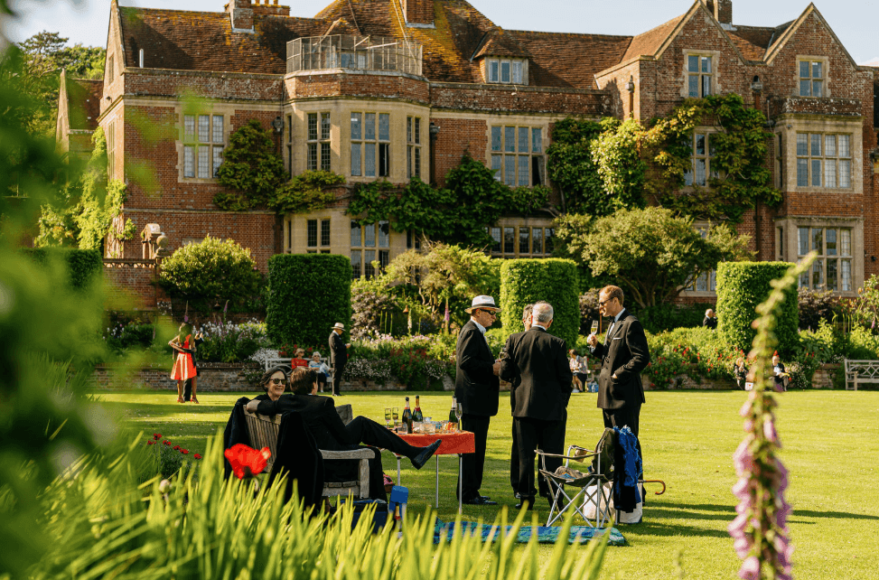 Self-Catering Holiday Cottage Accommodation In Sussex Guests socialising on the lawn outside a historic country house