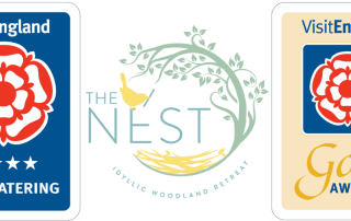 The Nest Idyllic Woodland Retreat logo with VisitEngland four-star self-catering and Gold Award accreditations